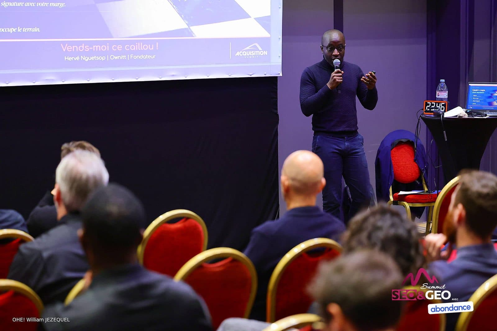 Hervé Nguetsop sur la scène de la salle D, conférence « Vends-moi ce caillou » au SEO & GEO Summit 2026
